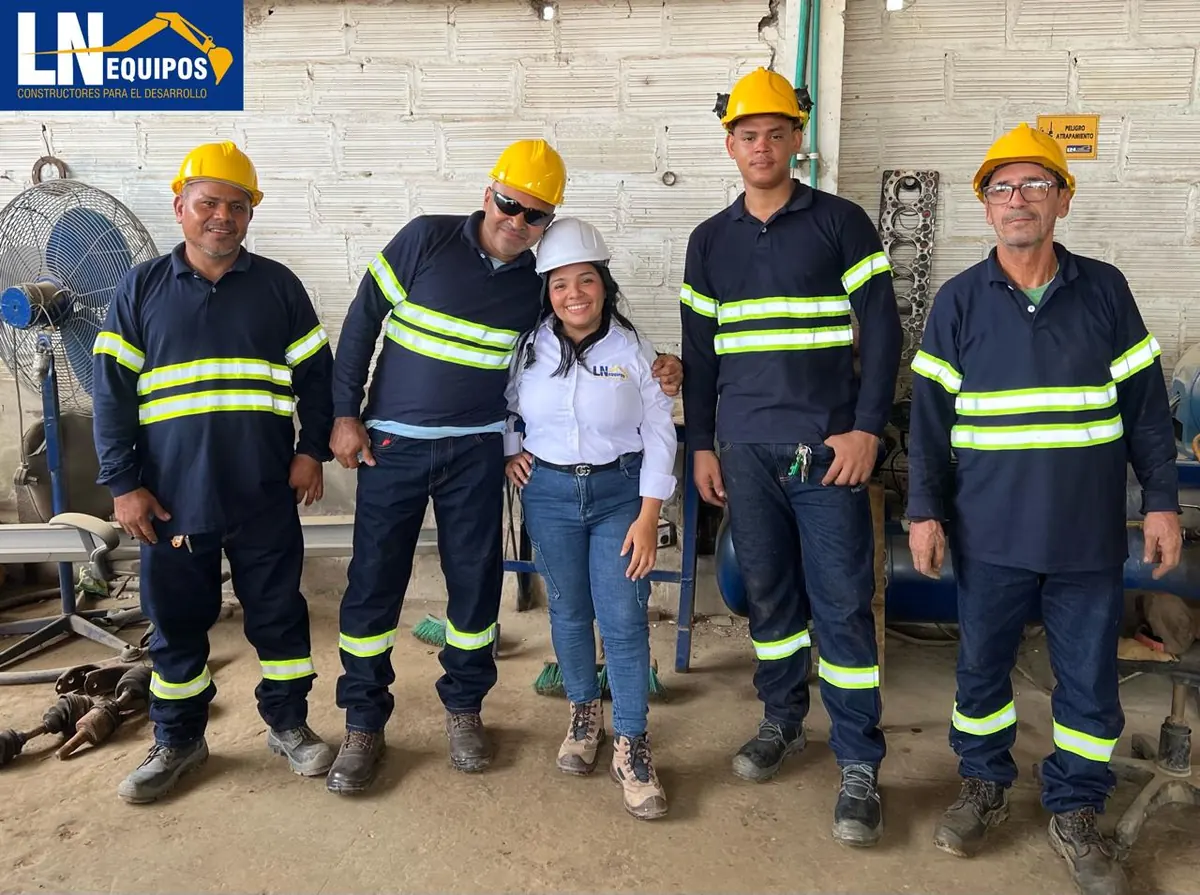 Equipo de LN Equipos con cascos y uniformes reflectivos en el taller